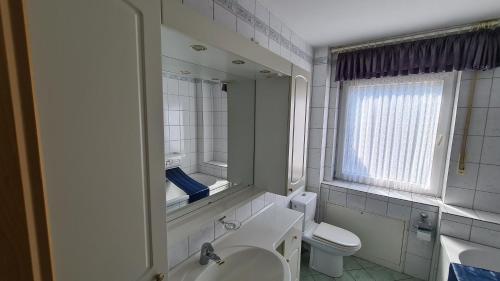 uma casa de banho com um lavatório, um WC e um espelho. em Ferienwohnung am Landschaftspark Duisburg-Nord em Duisburg