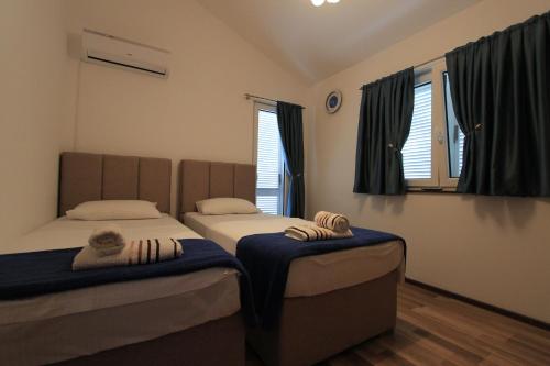 two twin beds in a room with windows at Bungalow 4 Suns in Virpazar