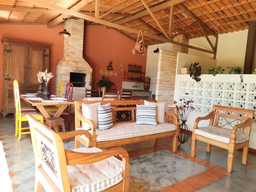 a living room with a table and chairs and a fireplace at Pousada Luz do Sol in Carrancas