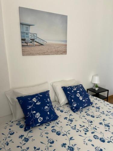 uma cama com lençóis azuis e brancos e uma imagem de uma praia em Liberty Hostel Lisbon em Lisboa