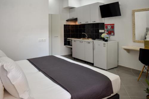 um quarto com uma cama e uma pequena cozinha em Aura Skiathos em Skiathos