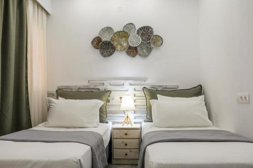 Duas camas sentadas uma ao lado da outra num quarto em Aura Skiathos em Skiathos