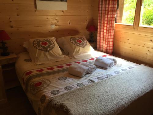 - un lit dans une cabane en rondins dotée de serviettes dans l'établissement La combe, à Morzine