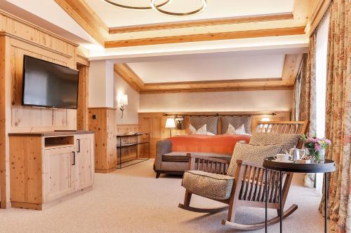 ein Schlafzimmer mit einem Bett und einem TV in einem Zimmer in der Unterkunft Superior Hotel Tirolerhof - Zell am See in Zell am See