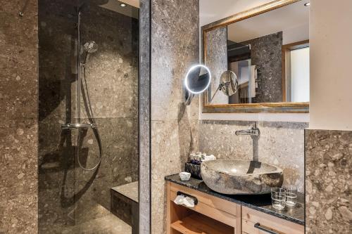 a bathroom with a sink and a shower at Superior Hotel Tirolerhof - Zell am See in Zell am See