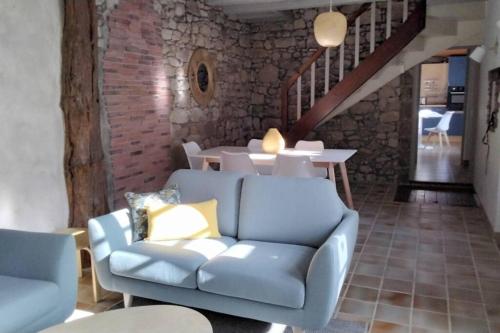 un soggiorno con divano blu e tavolo di Le logis de la Forge à 10 min du Puy duFou a Mortagne-sur-Sèvre