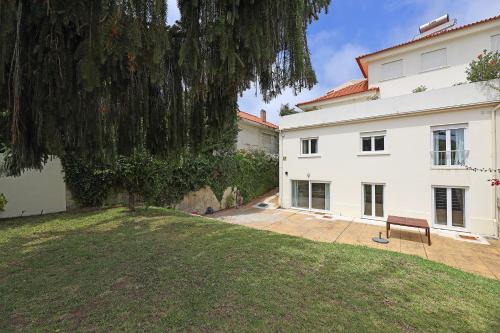 a bench sitting on a lawn in front of a building at FLH Serralves House with Garden in Porto