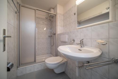 een badkamer met een wastafel, een toilet en een douche bij Studio Arosa von Swisspartments in Arosa