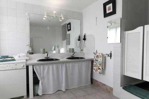 a bathroom with two sinks and a mirror at La Barcelle, une pause nature. in Perrigny