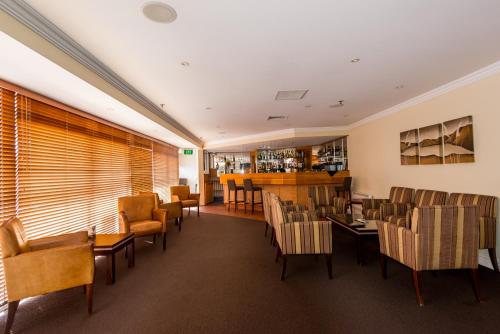 a restaurant with chairs and tables and a bar at VR Rotorua Lake Resort in Rotorua