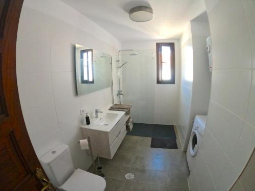 La salle de bains blanche est pourvue d'un lavabo et de toilettes. dans l'établissement Parque Santiago I - 2 Bedroom - 1 Bathroom - Open plan living - Kitchen area - Extra large balcony - First Floor Apartment, à Playa de las Americas