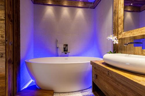 une salle de bain avec une baignoire blanche et un lavabo dans l'établissement Arc 1950, ambiance chalet luxe 5/7pers dans résidence 5* skis aux pieds avec SPA, à Arc 1950