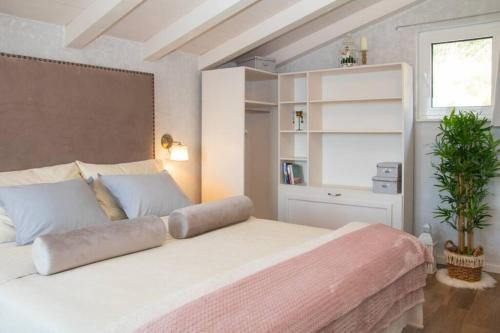 una camera da letto con un grande letto bianco e una pianta di Holiday home Parma a Šibenik