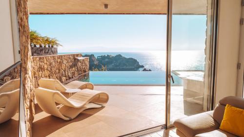 a living room with a view of the ocean at Isola Bella Infinity Suites in Taormina