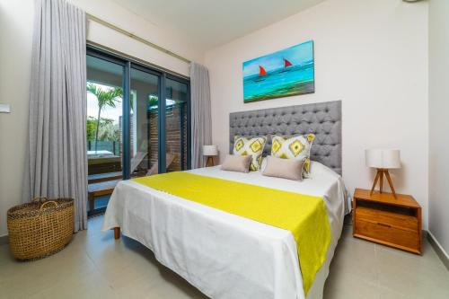a bedroom with a large bed with a yellow blanket at One Bay Residence Modern Contemporary Apartment Flat 4 in Grand Baie