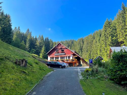 a building with a car parked on the side of a road at Penzion Zákoutí in Pec pod Sněžkou