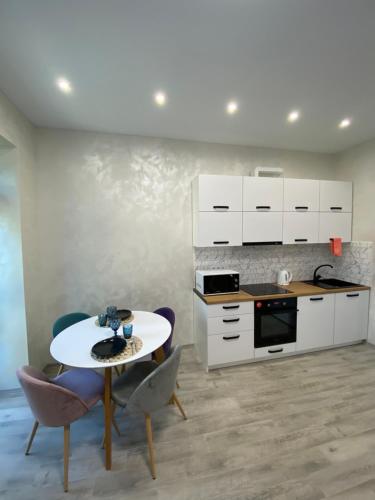 a kitchen with a table and two chairs and a counter at ЦЕНТР ЖК Театральний& АВТО ЖК Great House & ЦЕНТР ЖК Шевченка in Rivne