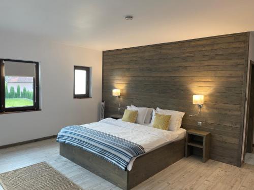a bedroom with a large bed with a wooden headboard at Montana 219 in Valea Drăganului