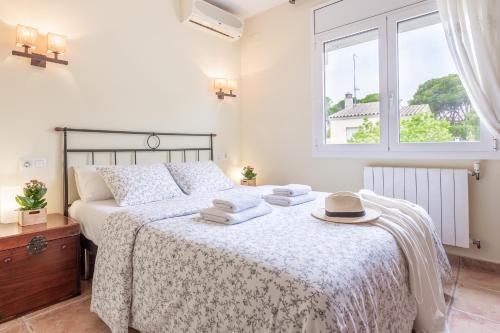1 dormitorio con 1 cama con toallas y ventana en Casa Hermosa, en L'Escala