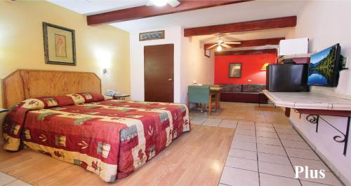 1 dormitorio con 1 cama y TV. en Hotel Suites Kino, en Hermosillo