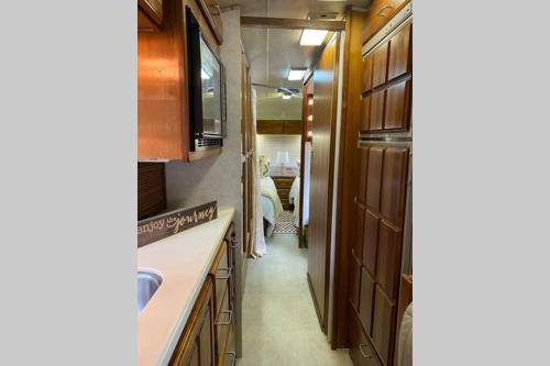a kitchen with wooden cabinets and a hallway at Beautiful Airstream, Beaufort SC-Enjoy the Journey in Beaufort