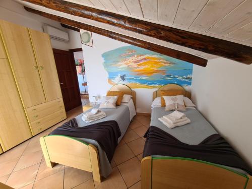 two beds in a room with a painting on the wall at Villa il Dolce Tramonto in Furore