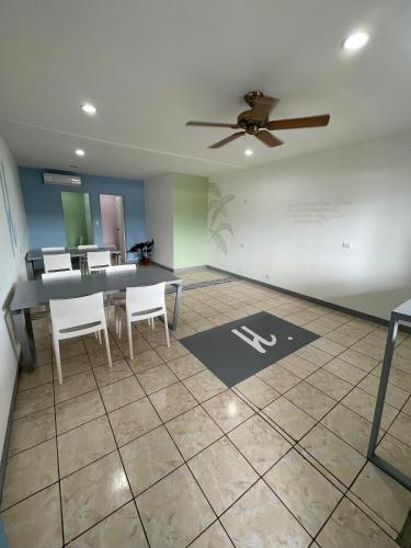 a dining room with a ceiling fan and a table and chairs at La Hacienda Rooms & Food in Jacó