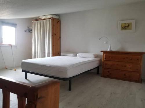 une chambre avec un lit et une commode en bois dans l'établissement Appartement dans la verdure près des plages, à Saint Cyprien Plage