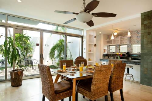 a dining room and kitchen with a table and chairs at Casa La Ceiba in Cancún