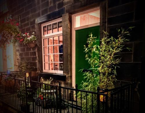 a green door and a window on a house at Hebden Bridge - House - Sleeps 8 - Pet Friendly in Hebden Bridge