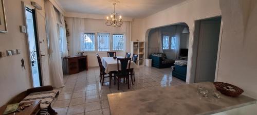a kitchen and dining room with a table and chairs at Villa Tikozidis in Nea Irakleia