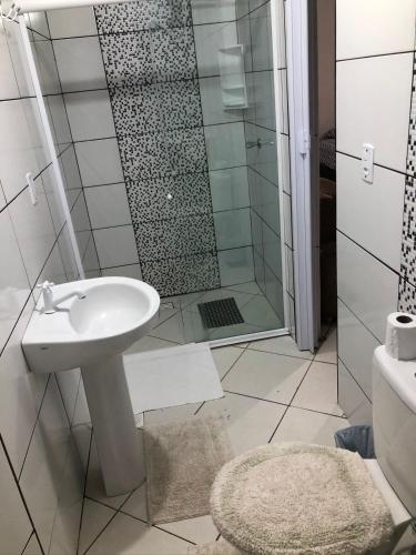 a bathroom with a sink and a shower at Pousada sol in Torres