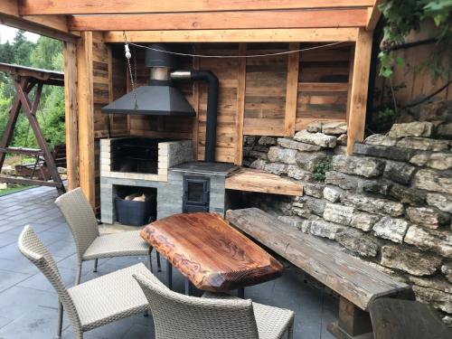 a patio with a wooden table and a fireplace at Chata Dorotka in Vyšné Ružbachy