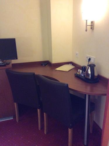 a desk in a hotel room with a table and chairs at Hotel-Pension Berger in Heidelberg