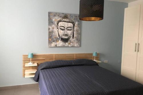 um quarto com uma cama com um quadro na parede em The Overhills Suite, your home away from home em Naxxar