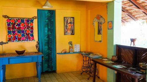 Habitación con escritorio azul y pared amarilla. en Cabinas Guarana en Puerto Viejo