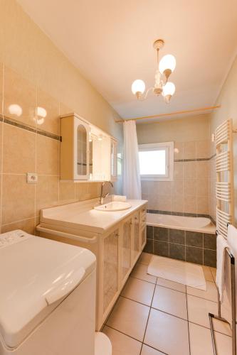 une salle de bain avec un lavabo, une baignoire et des toilettes dans l'établissement 85 m2, calme , parking, centre ville, à Aix-les-Bains