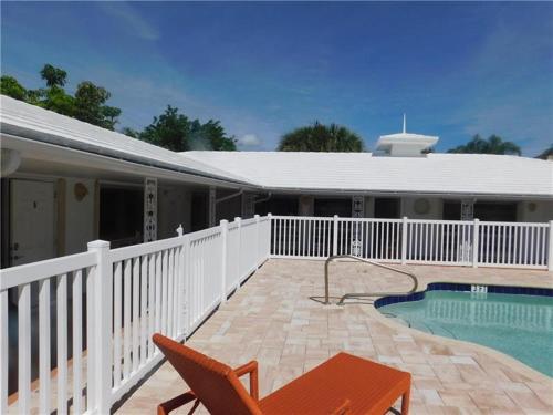 a house with a swimming pool and a white fence at Dolphin Isles Resort in Fort Lauderdale