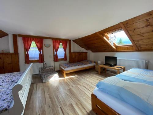 a bedroom with two beds and a television in it at Chalupa U kočky in Kovářská