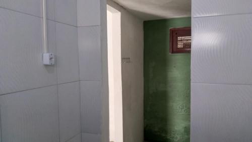 a bathroom with a shower with a green wall at Paracuru HolaOnda WaveHostel in Paracuru