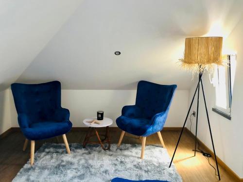 two blue chairs and a table in a room at Casas do Baleeiro - Whaler's Houses in Caniçal