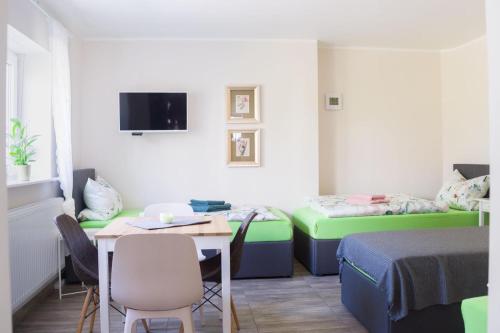 a small room with two beds and a table and chairs at Ferienwohnungen Margot in Iserlohn