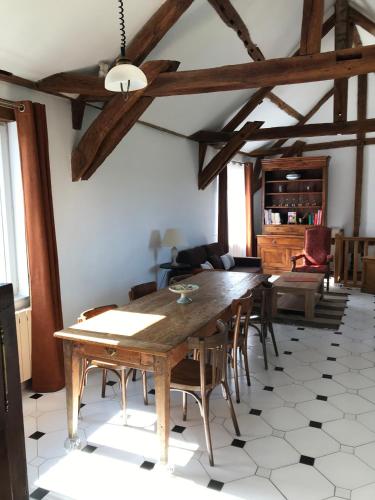 une salle à manger avec une table et des chaises en bois dans l'établissement La Barcelle, une pause nature., à Perrigny