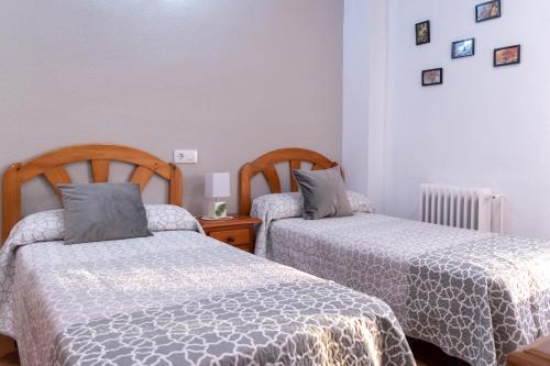 a bedroom with two beds and a table with a lamp at Alojamientos Rurales La Hoz in Beteta