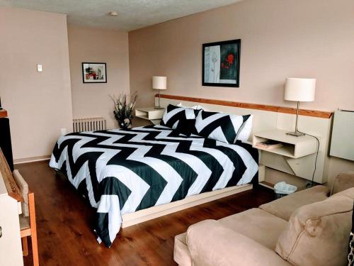 a zebra print bed in a room with a couch at Motel Belle Riviere in Saint-Jean-sur-Richelieu
