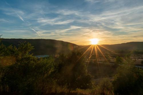 a view of the sun setting over the mountains at Alojamientos Rurales La Hoz in Beteta