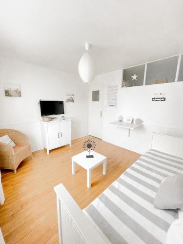 - un salon blanc avec un lit et une table dans l'établissement La Capitainerie, à Cancale