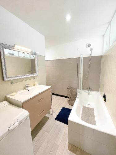 une salle de bain avec une baignoire et un lavabo et une baignoire dans l'établissement La Capitainerie, à Cancale