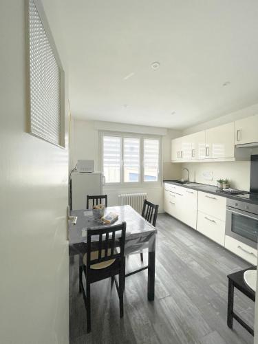 une cuisine et une salle à manger avec une table et des chaises dans l'établissement La Capitainerie, à Cancale