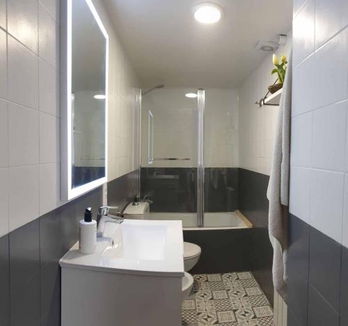 La salle de bains est pourvue d'un lavabo, de toilettes et d'une baignoire. dans l'établissement Casa Lola - Terraza panorámica en el centro del pueblo, à Sant Joan de les Abadesses